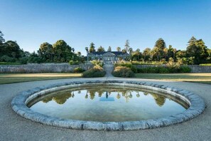 Stroll through the serene garden, surrounded by a tranquil water feature and lush greenery.