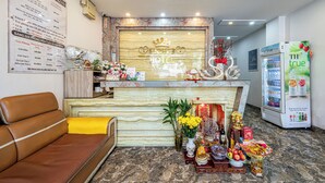 A hotel reception area with a marble counter, a brown leather sofa, and a refrigerator displaying 'TH true juice'. - Cozrum - Love Hotel Trần Bình Trọng (Ho Chi Minh City)