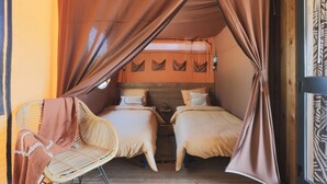 A cozy room with two beds, a chair, and a canopy. - ZEcamping 3* animaux acceptés piscine et restaurant (Saintes)