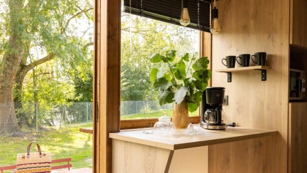 A compact kitchen with a wooden countertop, a coffee maker, and a potted plant. - ZEcamping 3* animaux acceptés piscine et restaurant (Saintes)