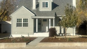 A two-story house with a front porch, a chimney, and a mailbox. - Charming Downtown Retreat  (Casper)