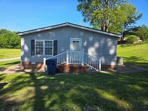 A small, single-story house with a front porch and a mailbox.