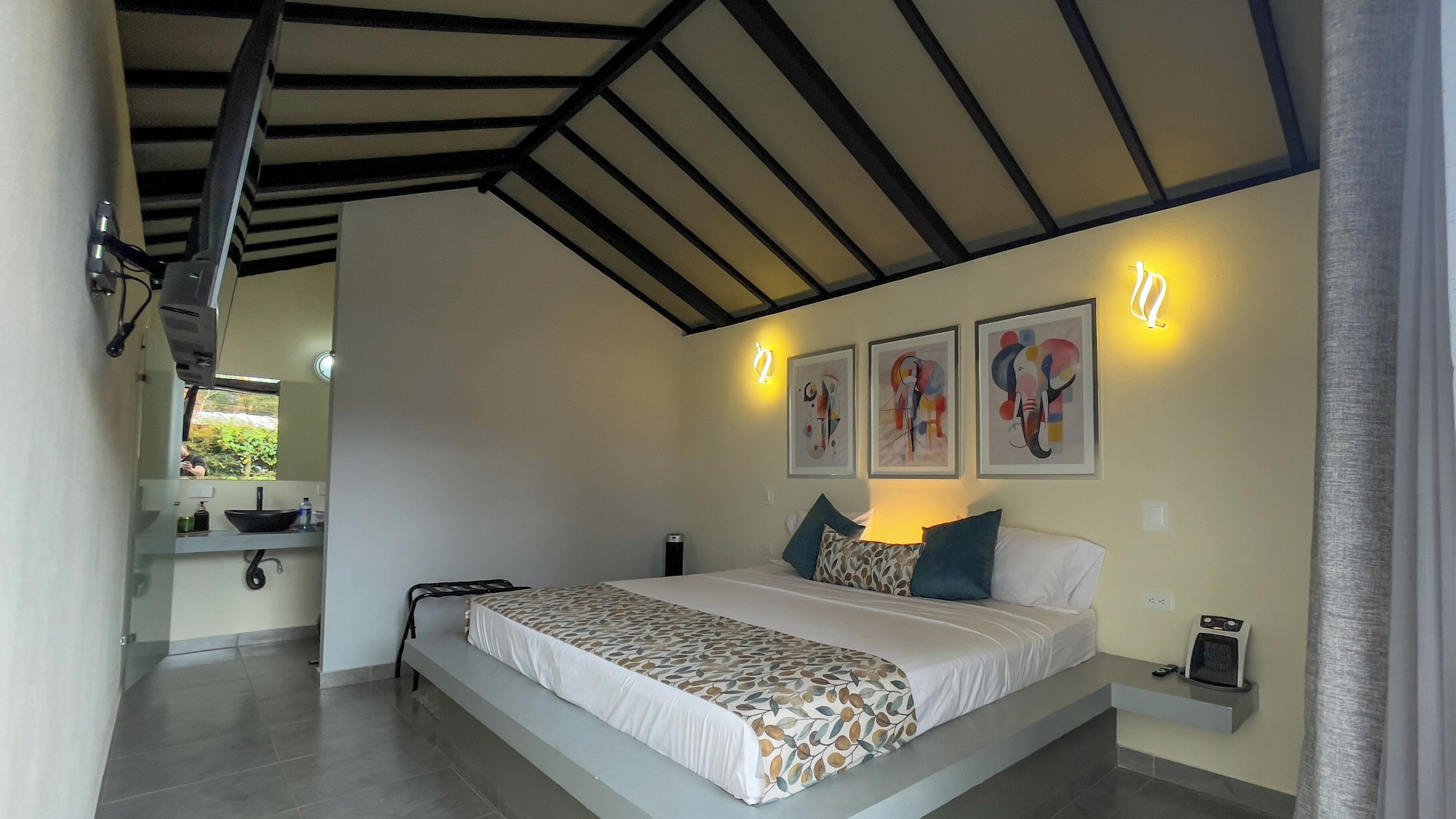 Una camera da letto con un letto, un comodino e un'opera d'arte appesa al muro.