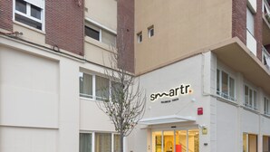 A building with a sign reading "smartr Valencia Turia" and a tree in front. - Smartr Valencia Turia (Valencia)