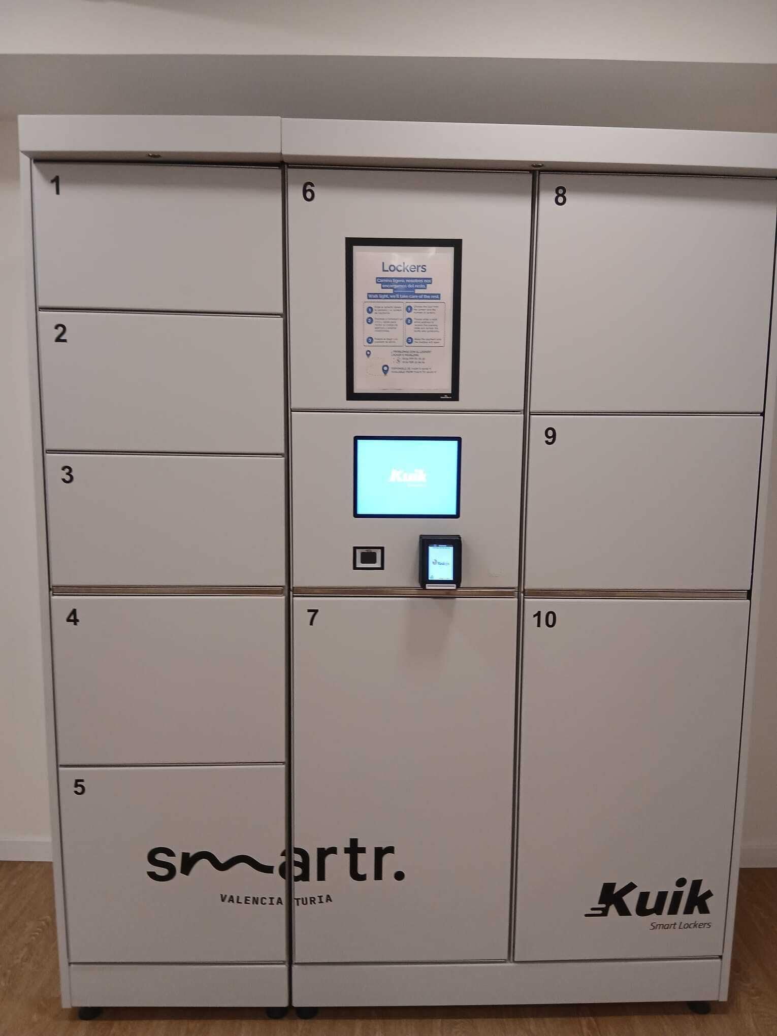 Une rangée de casiers numérotés de 1 à 10, un panneau de contrôle central et des logos pour les « casiers intelligents » de Kuik et les « casiers intelligents » de Smartr.