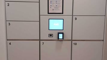 Una fila de casilleros con los números del 1 al 10, un panel de control central y la marca 'smart lockers' por Kuik y 'smart lockers' por Smartr.