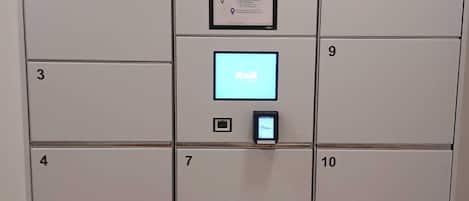 A row of lockers with numbers 1 to 10, a central control panel, and branding for 'smart lockers' by Kuik and 'smart lockers' by Smartr.