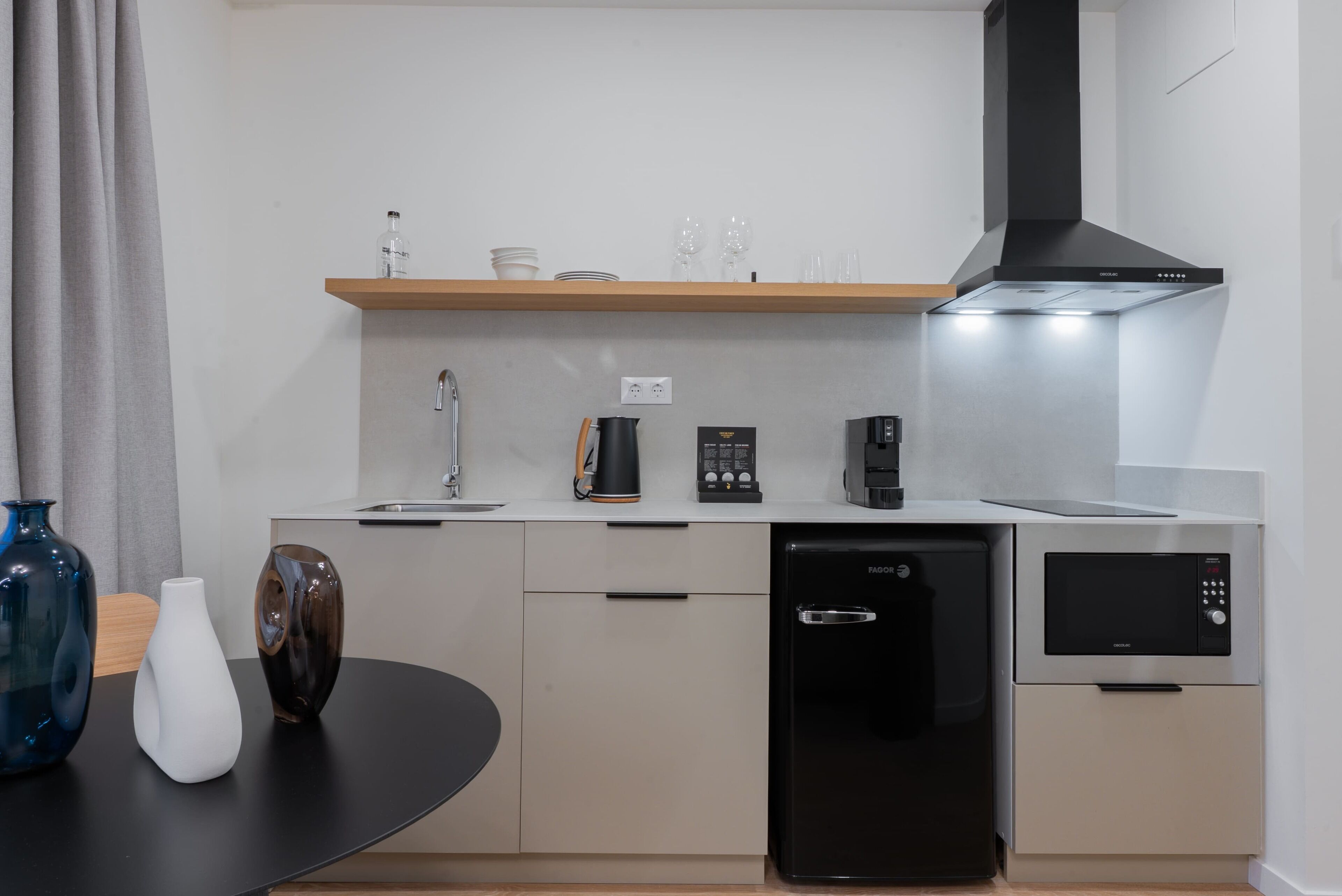 Una cocina moderna con lavavajillas, horno empotrado, cafetera y microondas.
