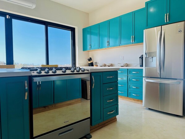 Enjoy cooking in this well-equipped kitchen with a refrigerator, gas stove, and ample storage.
