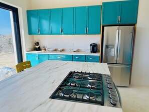Enjoy cooking in this well-equipped kitchen with a gas stove, refrigerator, and coffee maker.