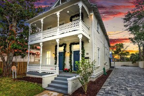 A white two-story house with a porch, a blue door, and a number '75' on the side. - Cedar Street Retreat A - Walk to Night of Lights! (St. Augustine)