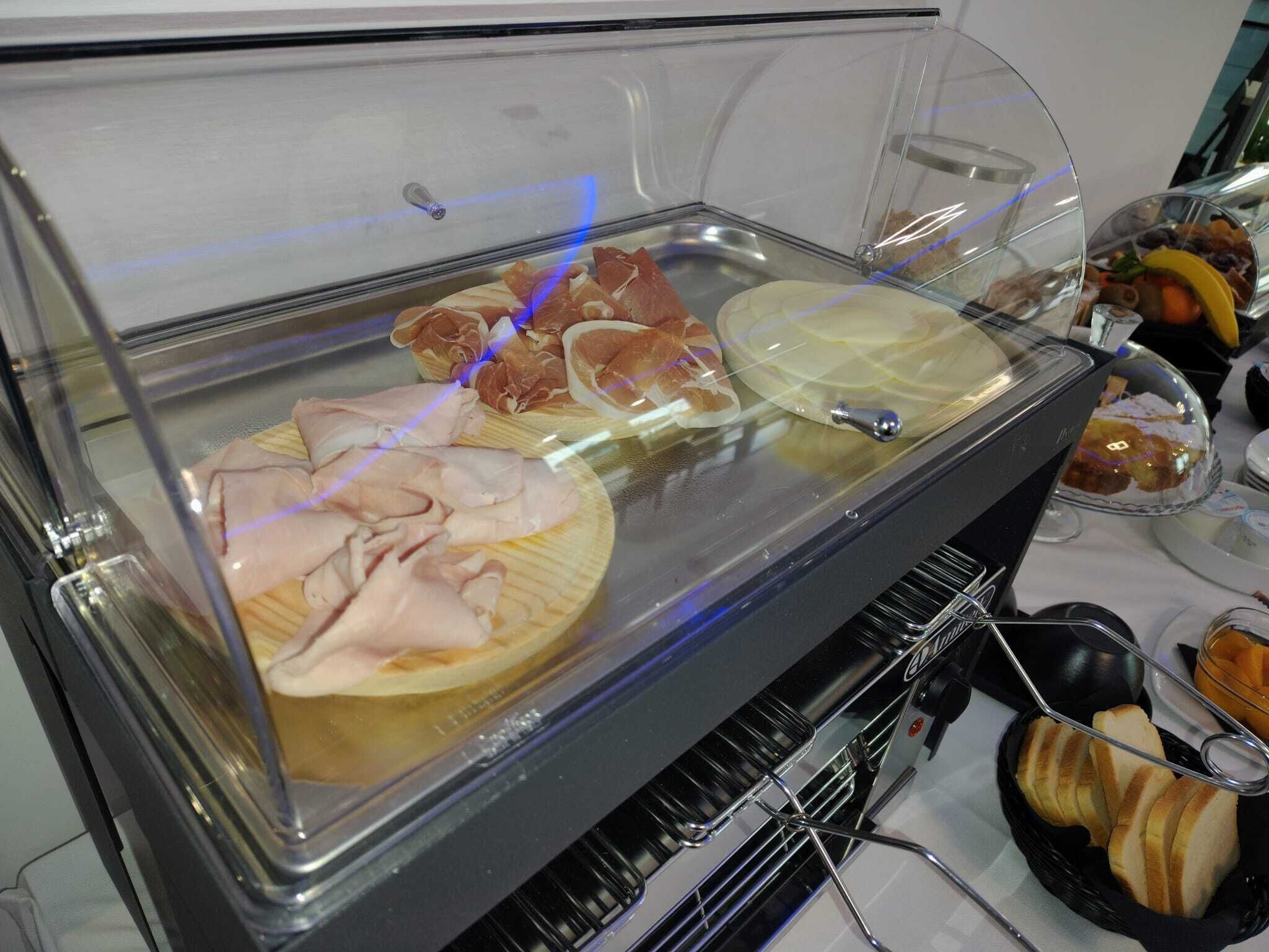 Un bufé con diversos alimentos, como embutidos, quesos y pan.