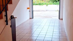 A hallway with a staircase leading to a covered outdoor area.