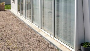A modern building with large glass windows, a gravel driveway, and a small garden area. - Atypical gîte Les Epinettes, 10 minutes from the beach in the Baie de Somme  (Cayeux-sur-Mer)