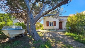 A house with a garden, a boat, and a clear sky. - T3 Paradise on the beach, feet in the water (Olmeto)