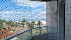 Un balcón con vista al océano y palmeras.
