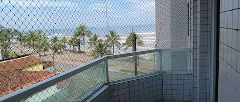 Un balcon avec vue sur l’océan et les palmiers.