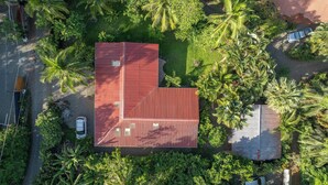 Un edificio de techo rojo rodeado de exuberante vegetación y palmeras.