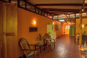 A spacious room with wooden flooring, a high ceiling, and a staircase leading to an upper level.