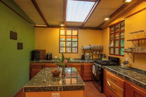 A kitchen with a central island, a window with a view, and a skylight.