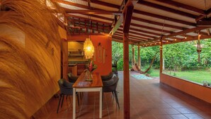 Un comedor interior con una mesa de madera, sillas y una lámpara colgante.