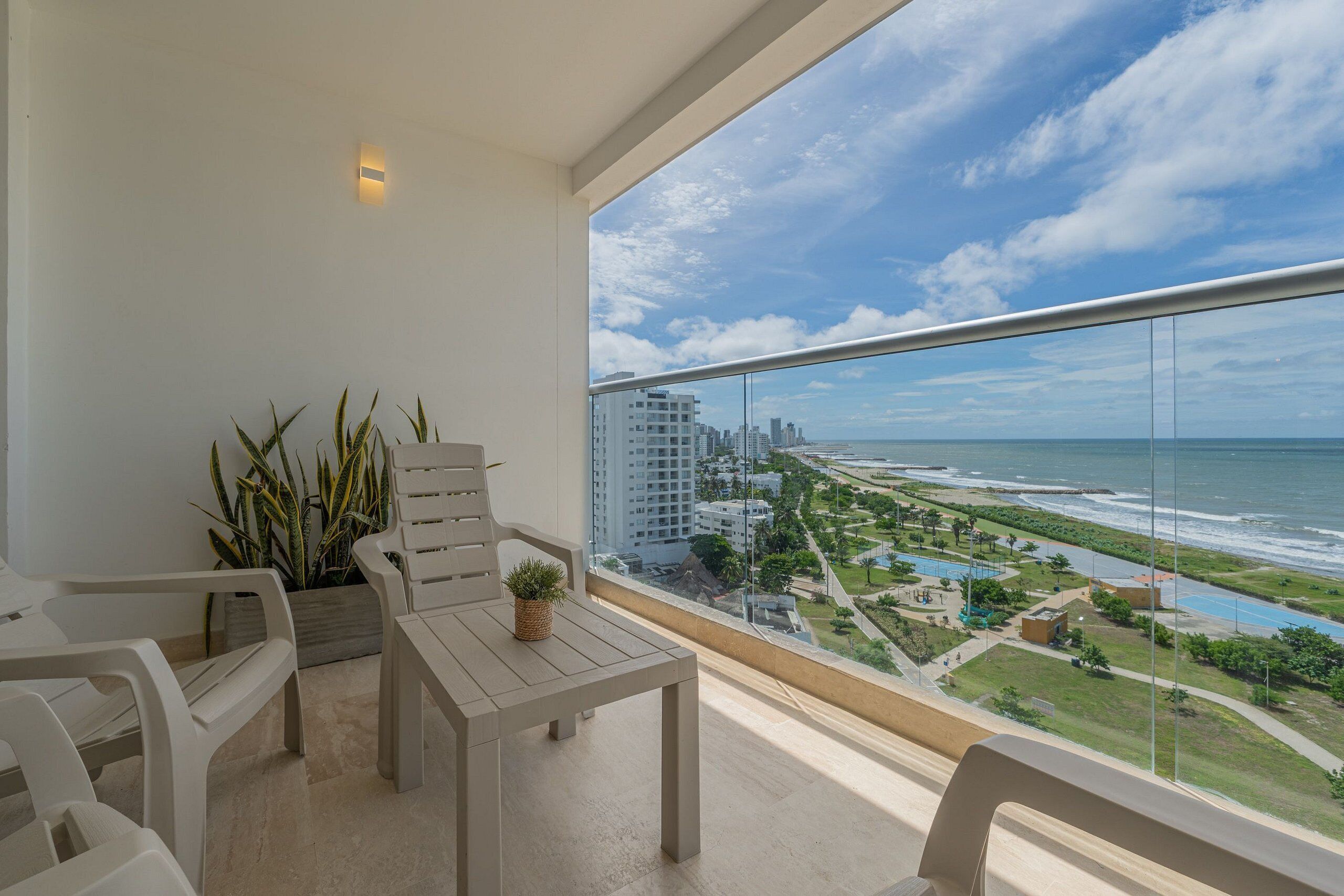 A balcony with a view of the ocean and cityscape.