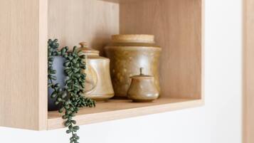 A wooden shelf with ceramic containers and a small plant.