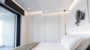 Ein modernes Schlafzimmer mit einem großen Bett, Blick ins Freie und minimalistischem Design.