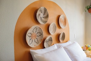 Experience the serene ambiance of this stylish room, featuring a unique circular design, a comfortable bed, and a touch of natural beauty.