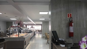 A modern kitchen with a buffet setup, a fire extinguisher, and a computer on a desk. - Spazzio diRoma Charme II with free entrance to Acqua Park, Splash Caldas Novas (Caldas Novas)