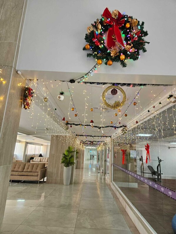 A hallway with festive decorations, including a wreath and string lights.