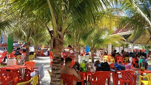 Guests can dine al fresco amidst lush palm trees and comfortable seating.