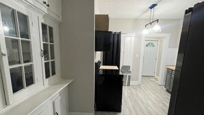 A kitchen with white cabinets, a black refrigerator, and a wooden countertop. - Magic City Home walkable to Top Golf, New Amphitheater, Uptown, City Walk &more! (Birmingham)