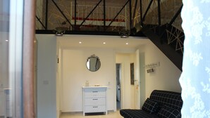 A modern room with a black and white checkered sofa, a white dresser, and a round mirror on the wall. - First-floor housing located within the city's Ancient Walls. (Castellammare del Golfo (TP))