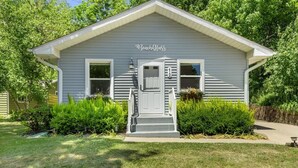 A single-story house with a front porch, a mailbox, and a small garden area. - Beach Glass block from Heart of Saugatuck! (Saugatuck)