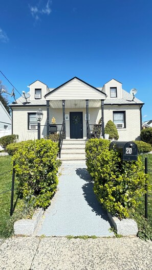 A two-story house with a front porch, a mailbox, and a well-maintained lawn. - Spacious 3-bedroom apartment with WiFi, AC in marvelous Carteret (Carteret)