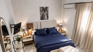 A modern bedroom with a large bed, bedside tables, a mirror, and a wall-mounted TV. - The Privacy Villa (6th of October City)