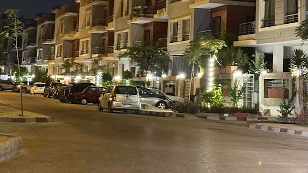 A row of modern multi-story residential buildings at night with street lighting. - The Privacy Villa (6th of October City)
