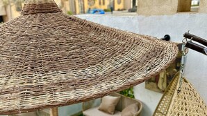 A wicker outdoor seating area with a hanging chair and a table. - The Privacy Villa (6th of October City)