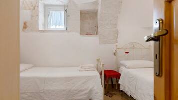 Een knus slaapkamer met twee eenpersoonsbedden, een raam en een deur.