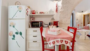 Cocina con refrigerador, microondas y mesa lista para comer.