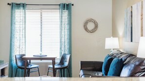 A living room with a sofa, two chairs, a table, and a lamp. - Adventure Loft: Near Trails, Pool and Golf (Sedona)
