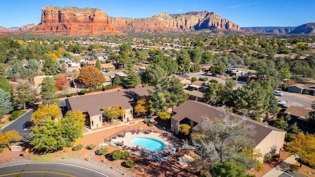 A residential area with houses, a swimming pool, and a view of red rock formations. - Adventure Loft: Near Trails, Pool and Golf (Sedona)