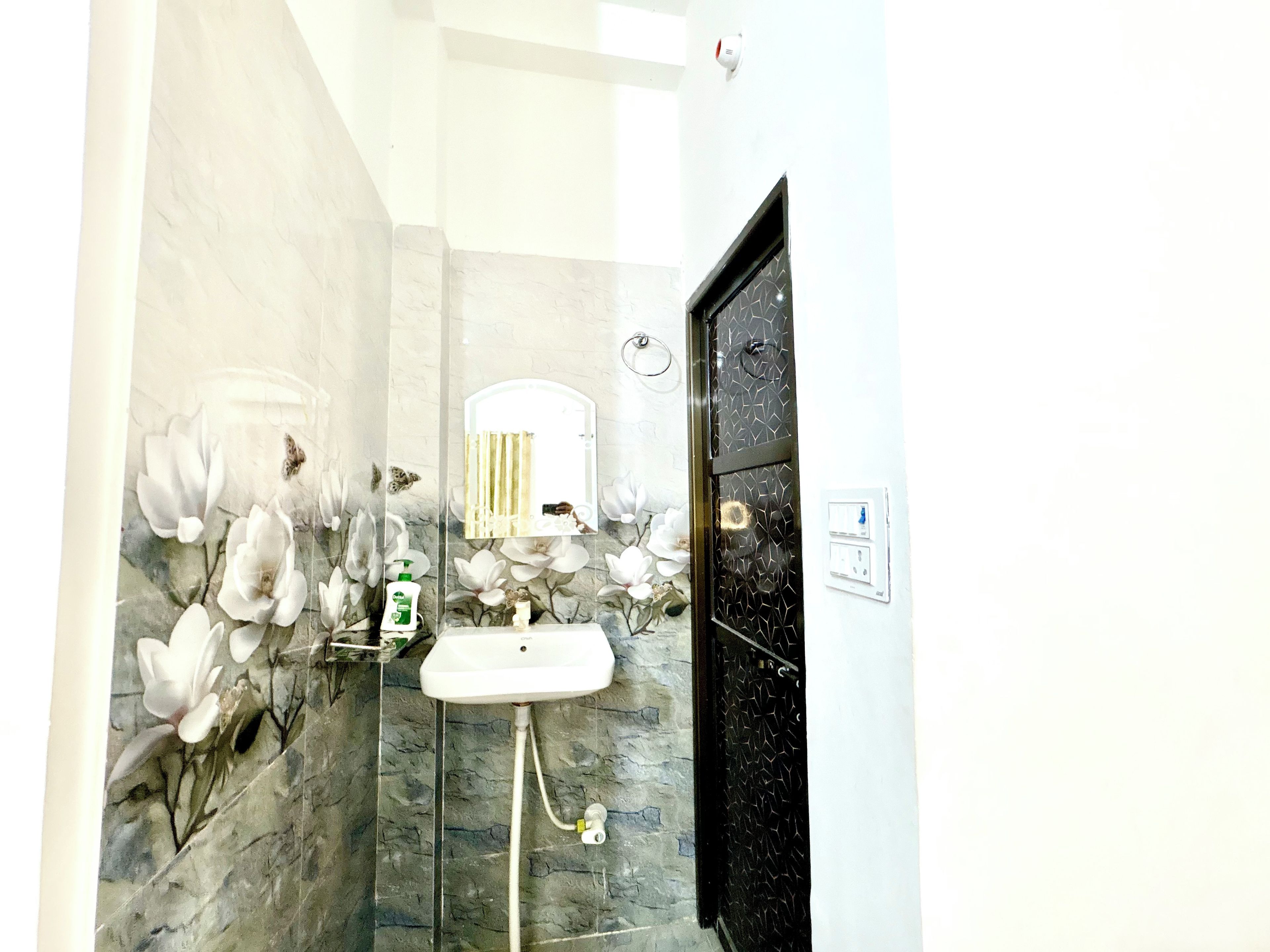 A bathroom with a white sink, a mirror, and a shower area.