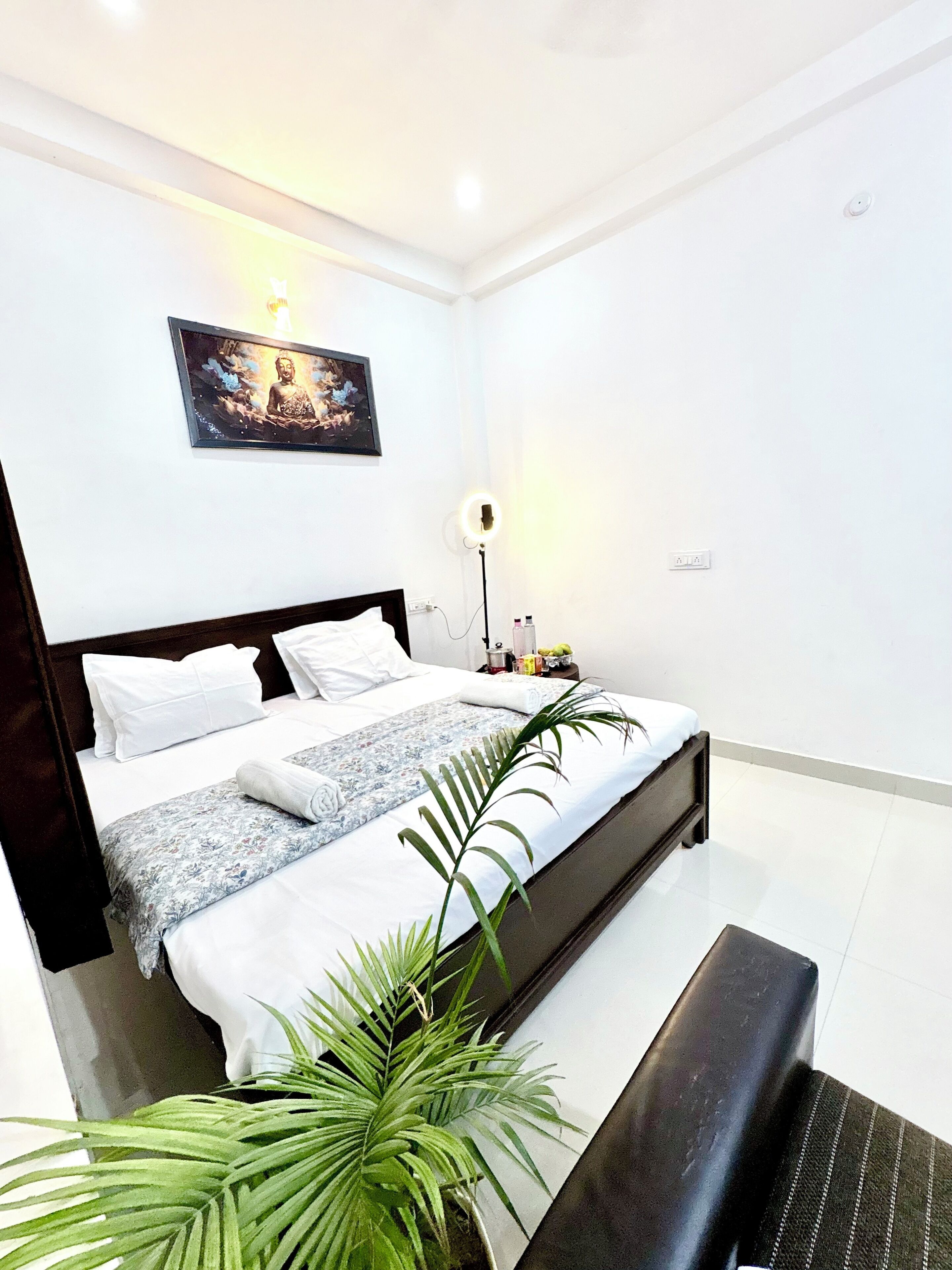 A modern bedroom with a bed, bedside table, lamp, and a framed picture on the wall.