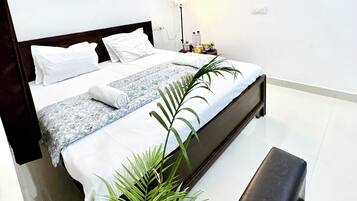 A modern bedroom with a bed, bedside table, lamp, and a framed picture on the wall.