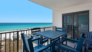 A balcony with a table and chairs overlooking a beach. - Emerald Towers 503 (Destin)