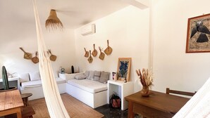 Een moderne woonkamer met een hangmat, een bank, een eettafel en een salontafel.