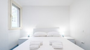 Una camera da letto con un letto, due comodini e una finestra.