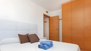 A hotel room with a bed, a nightstand, a wardrobe, and a door. - Apartment 'Tropikana I' with Shared Pool, Wi-Fi and Air Conditioning (Miami Platja)